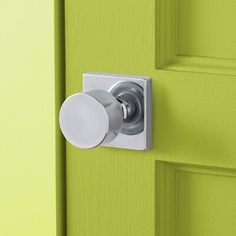 a close up of a door handle on a bright green door with a white knob