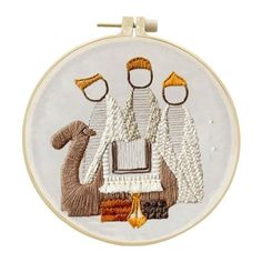 an embroidery kit with three people and a dog on it's back, in the middle