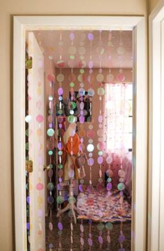 an open door to a room with polka dot decorations on the wall and curtains hanging from the ceiling