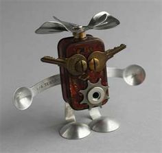 a small metal clock with two spoons on it's legs and one hand holding a wrench