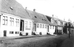 an old black and white photo of buildings on a cobblestone street in the early 20th century