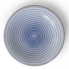 a blue and white plate with an intricate design on the rim, against a white background