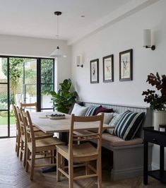 a dining room table with chairs and a bench in front of the door that leads to an outside patio