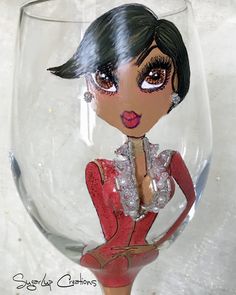 a close up of a wine glass with a doll in it