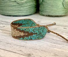 a close up of a beaded bracelet on a wooden table with yarn in the background