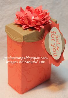 an orange box with a pink flower on it and a tag attached to the top