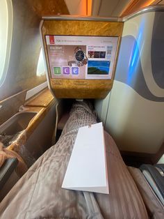 the inside of an airplane with a bed and laptop computer on it's side