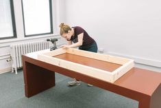 a woman is working on an unfinished table