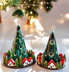 two small christmas trees sitting on top of a table