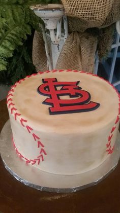 a cake decorated with the st louis baseball team on top of a table next to a chair