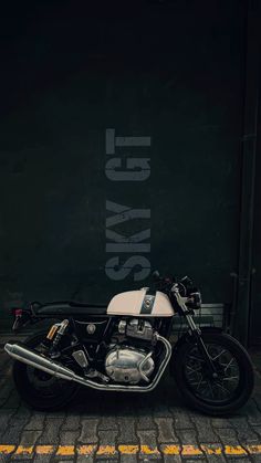 a black and white motorcycle parked in front of a building with the word stay on it