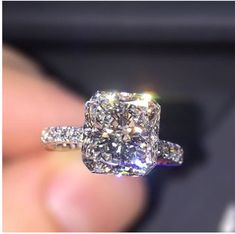 a close up of a diamond ring on someone's finger