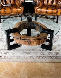 a living room with leather couches and a glass coffee table on top of it