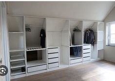 an empty room with white shelves and drawers