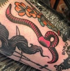 a close up of a person's arm with tattoos on it and a snake