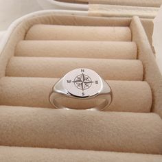 a compass ring sitting on top of an open box filled with beige carpeted boxes