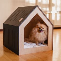 a small dog sitting in a wooden house shaped like it's own bed with his tongue hanging out