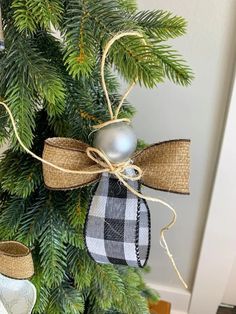 a christmas tree decorated with burlocks and plaid ribbon, hanging from the top