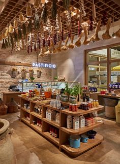 the inside of a restaurant with lots of food hanging from the ceiling and on shelves