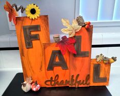 a wooden sign that says fall with leaves and acorns