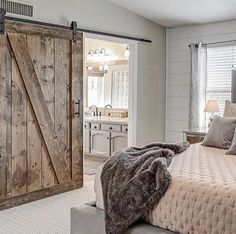 a bedroom with a large bed and sliding barn door