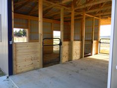 the inside of a horse barn with doors open