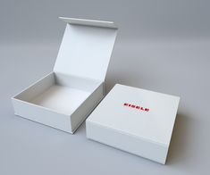 an open white box with red lettering on the lid and inside, sitting on a gray surface