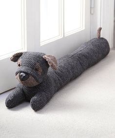 a stuffed dog laying on the floor in front of a door