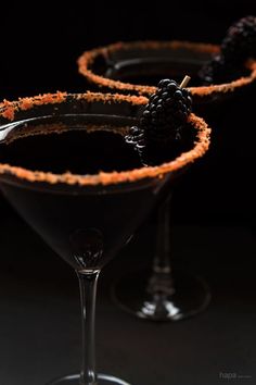 two martini glasses with blackberries in them