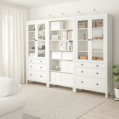 a living room filled with white furniture and lots of bookshelves on top of it