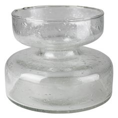 a clear glass candle holder on a white background with water droplets all over the base