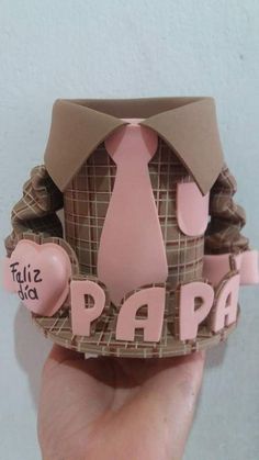 someone is holding up a paper hat that says papia with pink and brown accents