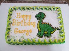 a birthday cake with green frosting and a dinosaur on the side that says happy birthday george