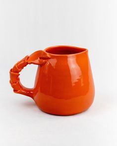 an orange mug with a handle is shown