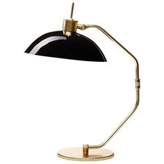 a black and gold desk lamp with a white base on an isolated surface against a white background