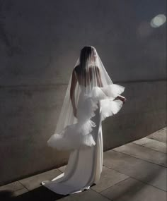 a woman in a white wedding dress and veil