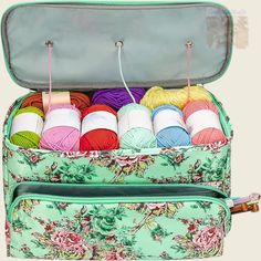 an open suitcase filled with yarn and crochet hooks on top of each other