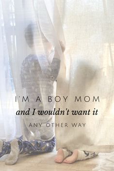 a woman standing next to a curtain with the words i'm a boy mom and i wouldn't want it any other way