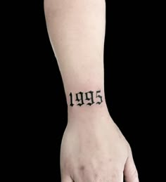 a person's hand with a tattoo that reads 1989 on the left side of their wrist