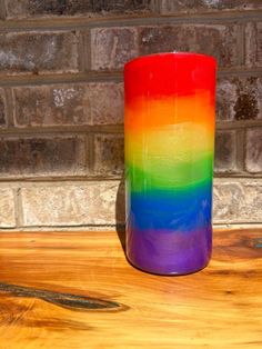 a rainbow colored glass sitting on top of a wooden table