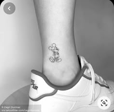 a small mickey mouse tattoo on the ankle