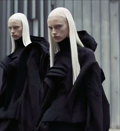 two mannequins dressed in black and white are walking down the street together