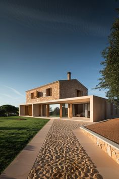 the house is made out of stone and has a walkway leading up to it's entrance