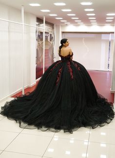 a mannequin wearing a black dress in a room with white tiles on the floor