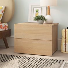 a wooden dresser sitting next to a lamp on top of a rug in a living room