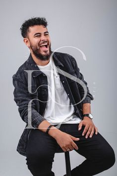 a man sitting on top of a chair laughing