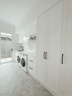 a white laundry room with washer and dryer next to it's doors