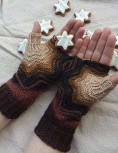 a person wearing knitted mittens and holding out their hands with cookies in the shape of stars