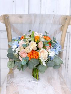 a bridal bouquet sitting on top of a chair in front of a white wall