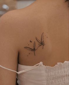 the back of a woman's shoulder with two dragonflies on it